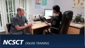 health professional sat at desk with patient